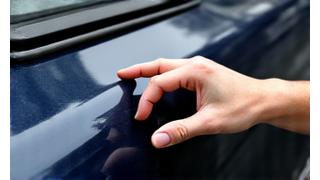 Main appliquant de la cire de protection sur la carrosserie d'une voiture, pour un traitement premium